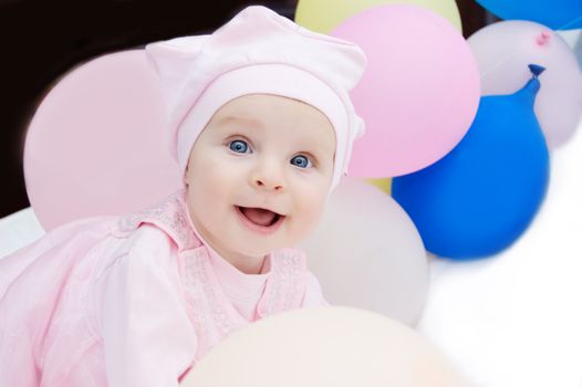Happy baby girl in pink with balloons