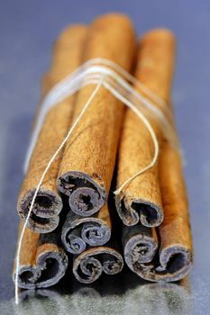 Cinnamon sticks tied with a string isolated on a gray background.