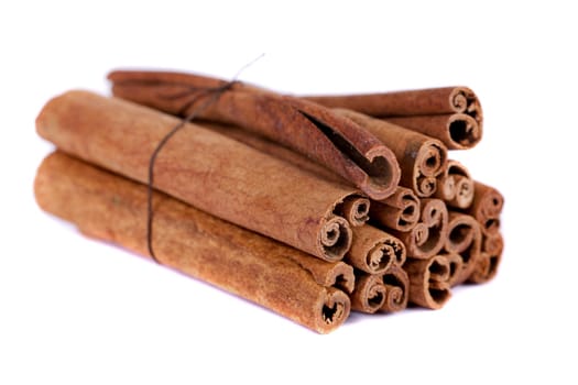 View of a bunch of cinnamon spice quills isolated on a white background.
