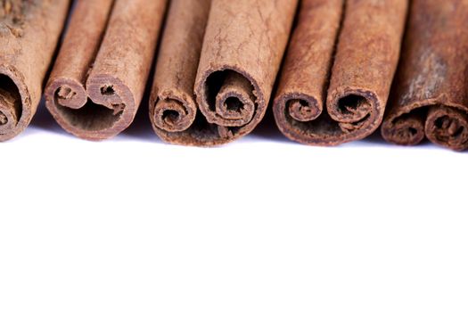 View of a bunch of cinnamon spice quills isolated on a white background.