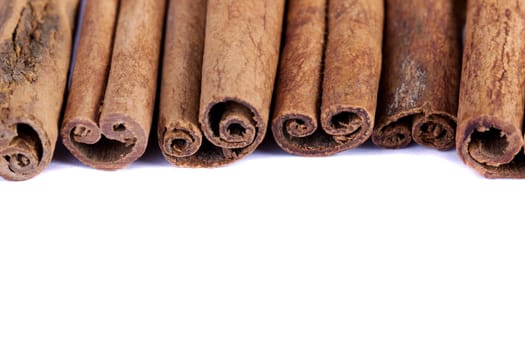 View of a bunch of cinnamon spice quills isolated on a white background.