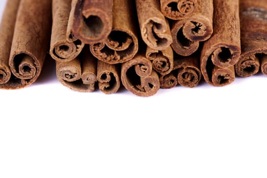 View of a bunch of cinnamon spice quills isolated on a white background.