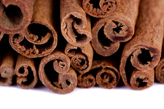 View of a bunch of cinnamon spice quills isolated on a white background.