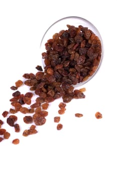 Close view of a pile of dry raisins on a bowl isolated on a white background.
