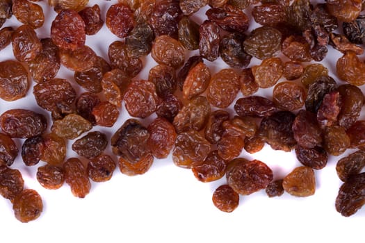 Close view of a pile of dry raisins isolated on a white background.