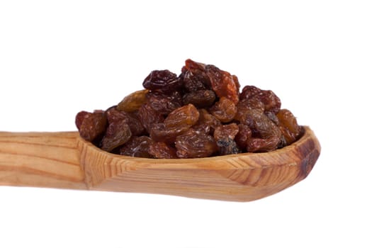 Close view of a wooden spoon filled with dry raisins isolated on a white background.