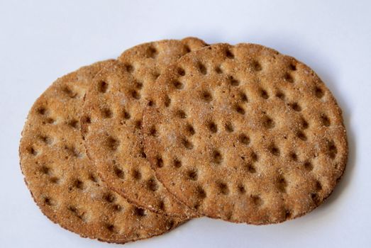 Three slices of hard rye bread on a white surface.