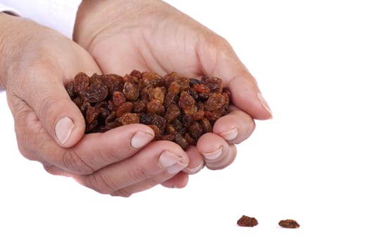Close view of a pair of hands holding some raisins isolated on a white background.