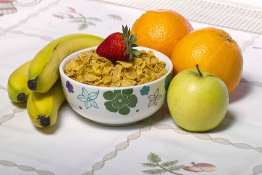 View of a bowl of cereals surrounded by fruit.