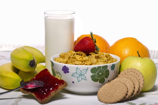 View of a bowl of cereals surrounded by fruit and milk.