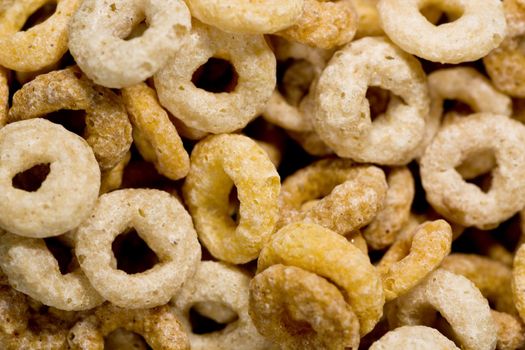 Close up view of many donut shaped cereals on a bowl.