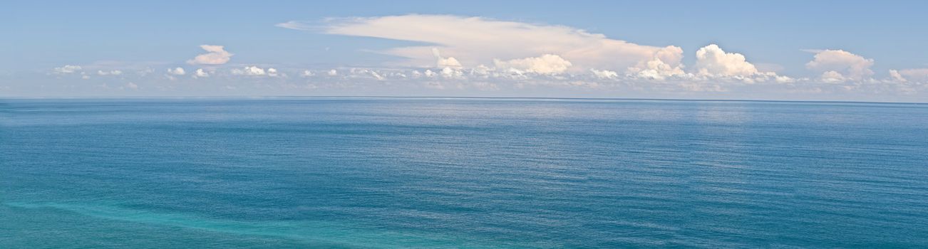 Ocean scenery in panorama in daytime under blue sky.