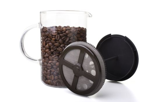 French press full of coffee beans, vertical orientation.
