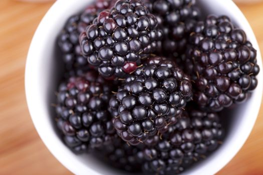 Closeup of blackberries in bowl shot from directly above.