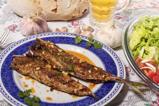 Close up view of a Portuguese meal of Wahoo grilled fish with annatto sauce and Mediterranean salad.  