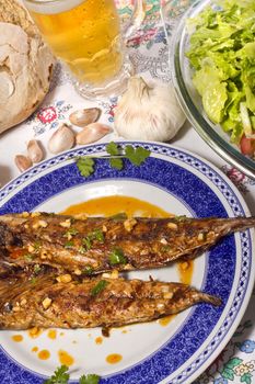 Close up view of a Portuguese meal of Wahoo grilled fish with annatto sauce and Mediterranean salad.  