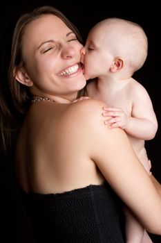 Baby kissing laughing mother