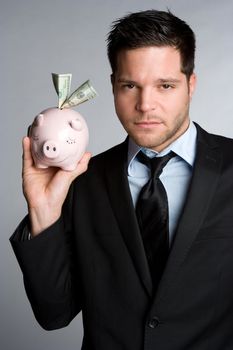 Handsome man holding piggy bank