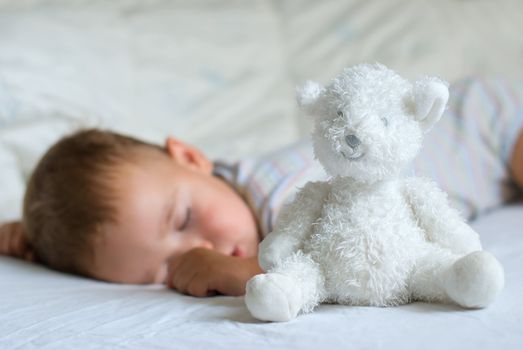 Sweet dream - white bear against sleeping little boy