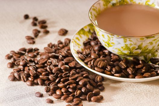 roasted coffee beans and a cup full of coffee