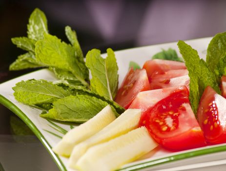 dish of various vegetables such as tomatoes, cucumbers and mint