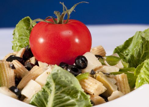 antipasto salad with lettuce, tomatoes, olives and corn