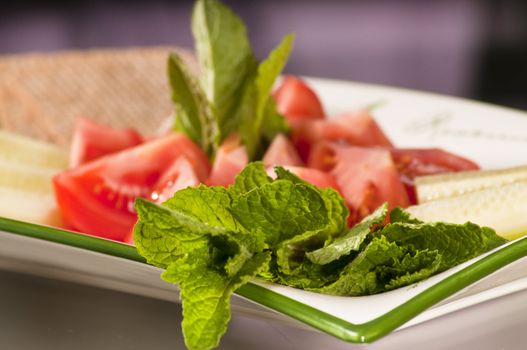 dish of various vegetables such as tomatoes, cucumbers and mint