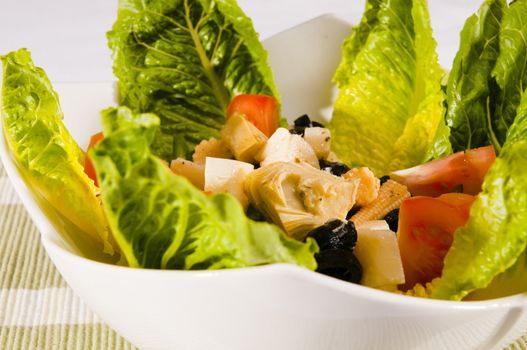 antipasto salad with lettuce, tomatoes, olives and corn