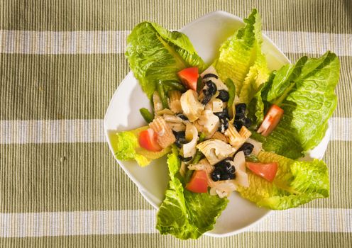antipasto salad with lettuce, tomatoes, olives and corn