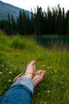 woman relaxing on the grass near a lake