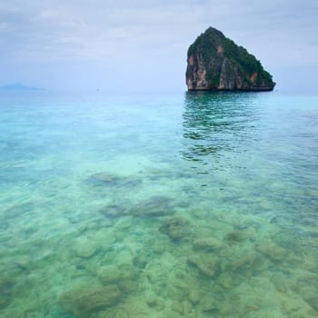 Lonely rocky island in turquoise sea