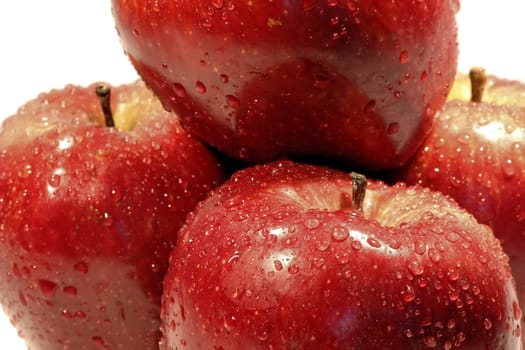 Bunch of red apples, on top of each other, isolated on a white background, with drops of water.