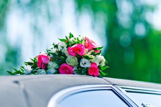 A bunch of roses on the roof of wedding car