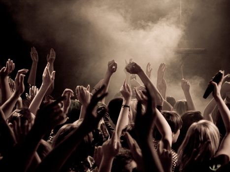 Crowd at a concert with hands up in the air