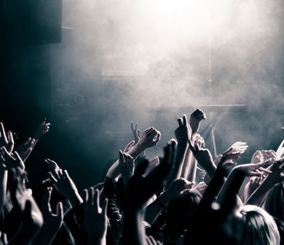 Concert crowd with hands up, toned