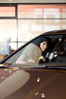 Young woman looking at new car