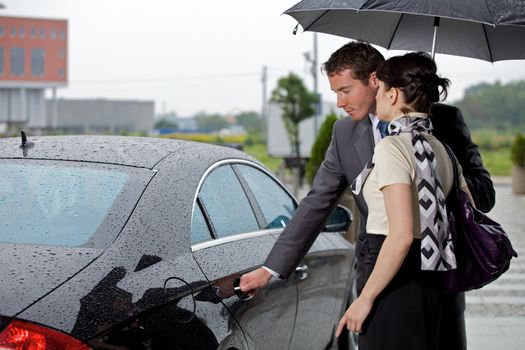 Young man opening door of car for woman
