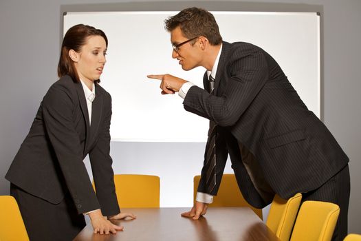 Businessman pointing towards businesswoman in office