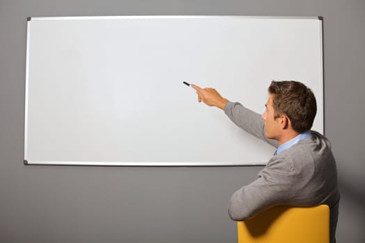 Businessman pointing at whiteboard in office