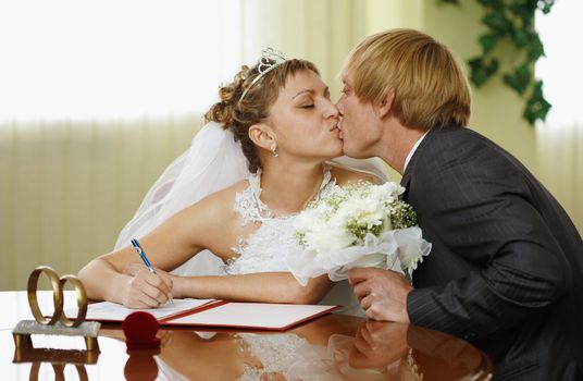The bride and groom kiss during the ceremony of marriage