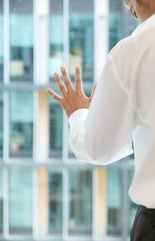 Young caucassian businessman standing against office window