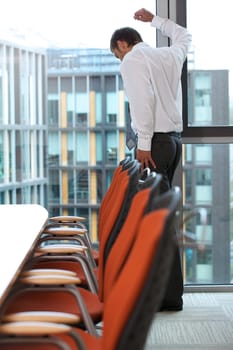 Young caucassian businessman standing against office window