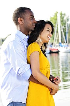 Young romantic couple hugging and standing at harbor in profile