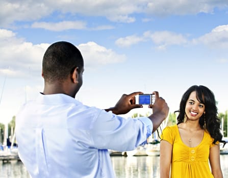 Beautiful woman posing for vacation photo at harbor with sailboats