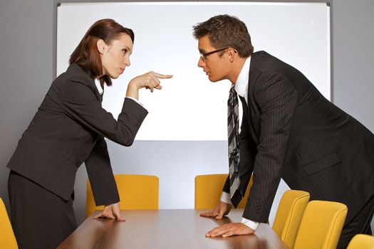 Businesswoman pointing towards businessman in office