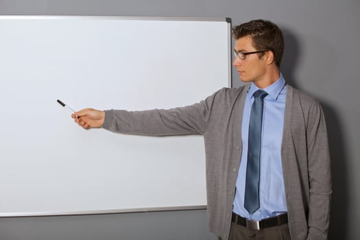 Businessman pointing at whiteboard in office