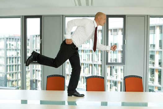 young confident caucasian businessman running on the office table