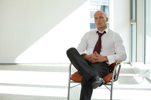 young confident caucasian businessman sitting on office chair