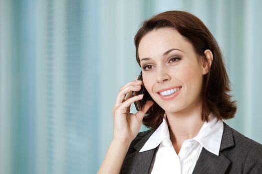 Portrait of young caucasian businesswoman talking on cellphone i