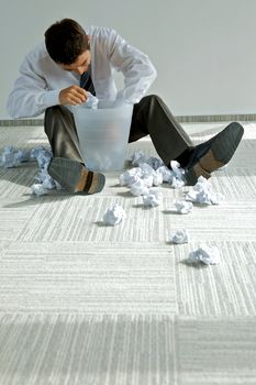 young caucasian businessman seeking document in trash bin